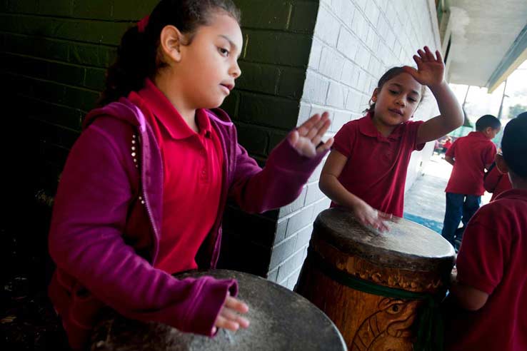 Kindergartener Zoe, right, plays the drums during recess at Academia Semillas del Pueblo on Dec. 5. The LAUSD charter school incorporates language and cultural learning.