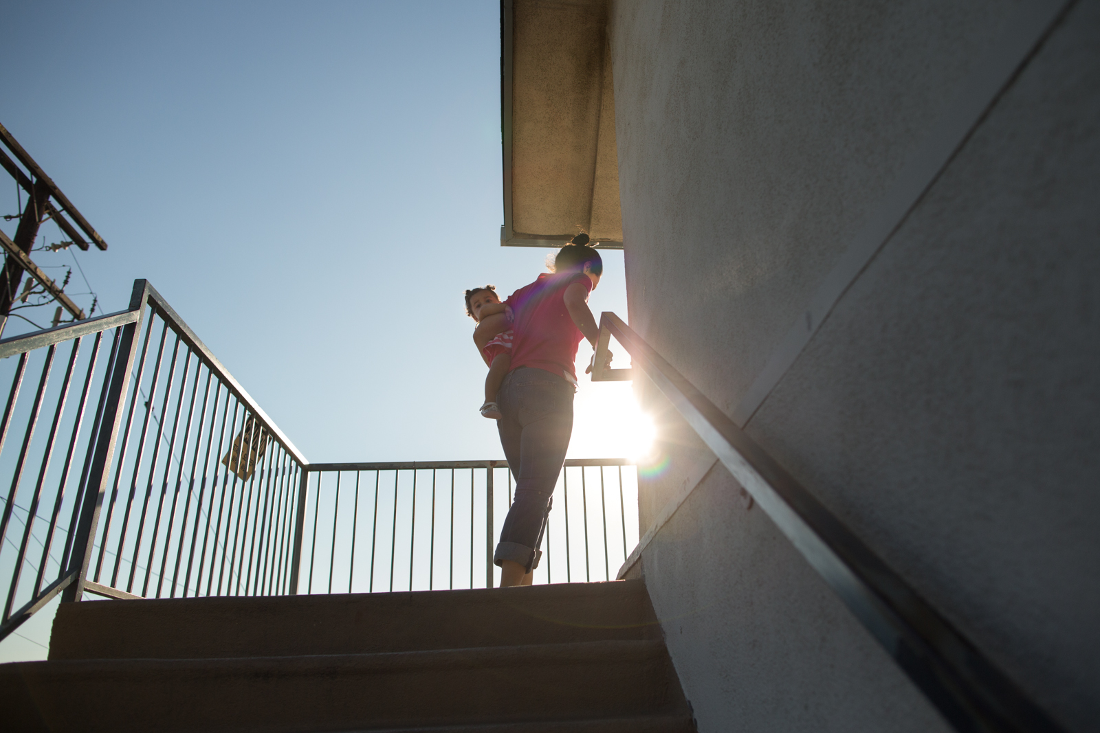 Christina Bray walks up stairs at the Community Prisoner Mother Program in Pomona, Calif. with her daughter Lola. Bray is serving time for stealing over $1 million dollars from an elderly client of JP Morgan Chase bank in San Jose, where she worked as a manager.